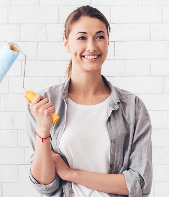 young-woman-holding-paint-roller-for-renovation-at-YVK8WJV.jpg